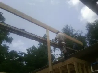 Carpenter setting a ridge beam over a new addition frame — Ice Dam Removal by Roofing Brothers in Spring Mills