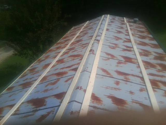 Rusted metal roof panels with new wood purlins before replacement — Storm Damage Roof Repair in Spring Mills by Roofing Brothers