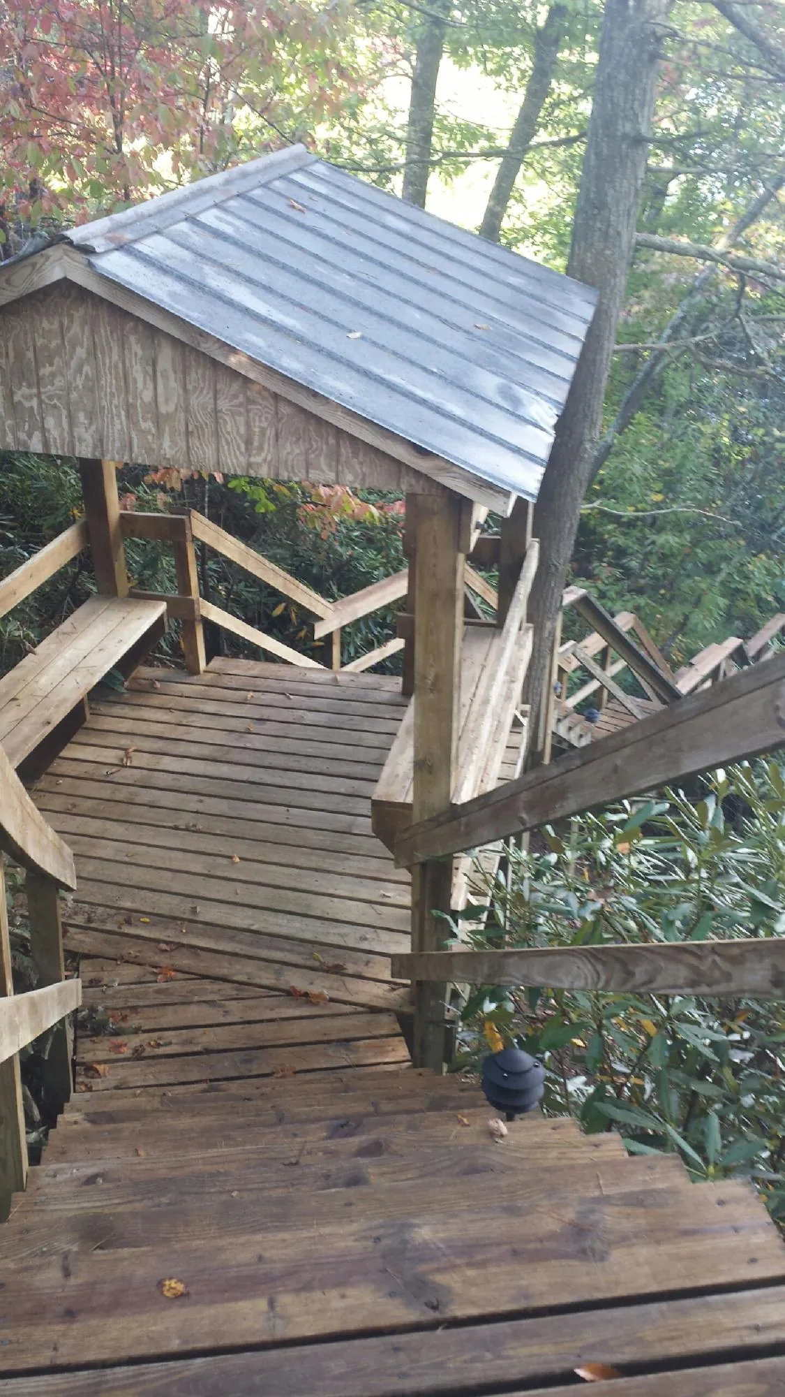 Metal roofed shelter over wooden steps on a wooded walkway — Skylight Repair & Installation work by our crew in Spring Mills