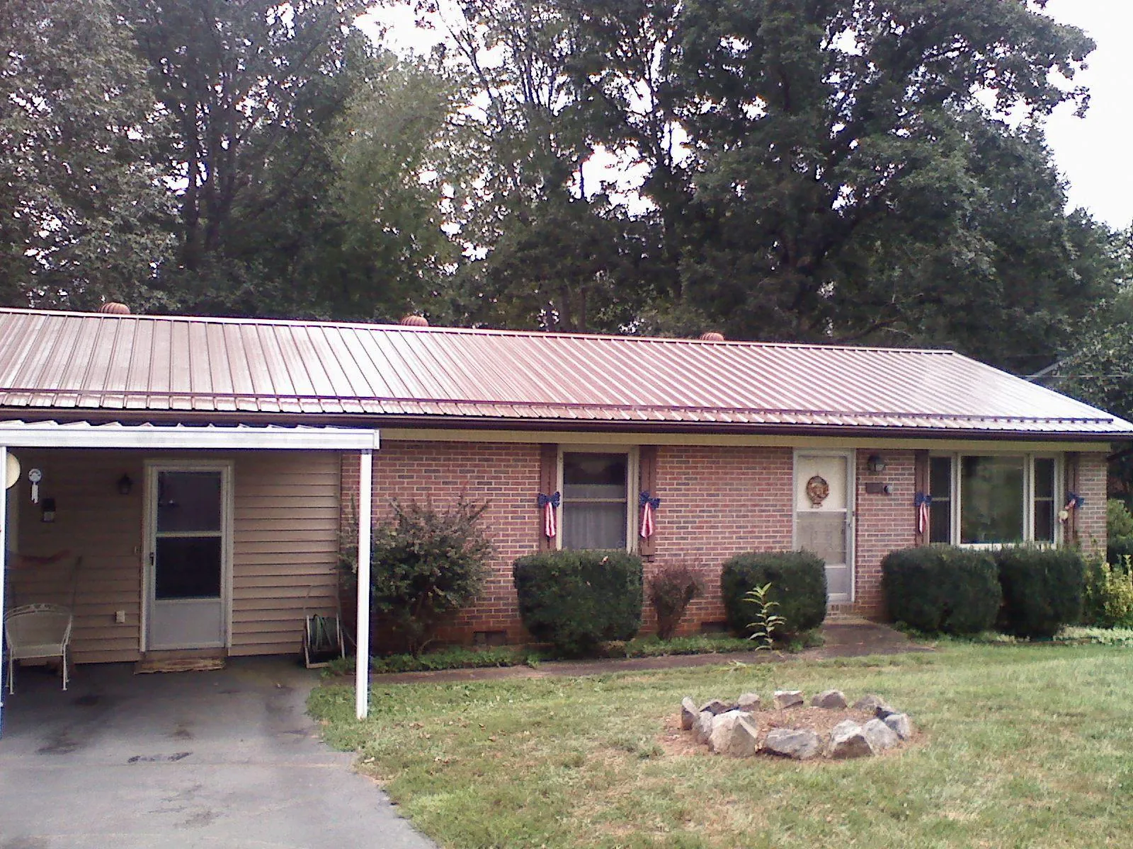 Bronze metal roof and carport on a brick ranch home — Roof Repair work by our crew in Spring Mills